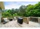 Outdoor deck with a grill and furniture, overlooking a green, wooded backyard at 33 Kay Ne Rd, White, GA 30184