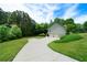 Long driveway leading to a two-car garage, surrounded by a lush lawn and mature trees at 33 Kay Ne Rd, White, GA 30184
