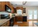 View of a kitchen area with stainless steel appliances and wood cabinets, adjacent to outdoor patio access at 33 Kay Ne Rd, White, GA 30184