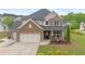 Charming two-story home with a stone and siding exterior, well-manicured lawn, and inviting front porch at 800 Ivy Crest Ln, Canton, GA 30115