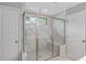 Modern bathroom shower featuring a glass enclosure, marble-like tile, and bench seating at 800 Ivy Crest Ln, Canton, GA 30115