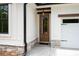 Home's entryway features a wood door, stone accents, and a charming pendant light at 130 Doris Path, Dallas, GA 30157
