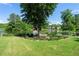 Spacious backyard featuring a well-maintained lawn, mature trees, and serene lake views with manicured landscaping at 2436 Camden Lake Nw Vw, Acworth, GA 30101