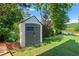 Well-maintained backyard with a storage shed, lush greenery, and tranquil lake views at 2436 Camden Lake Nw Vw, Acworth, GA 30101