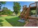 Backyard view featuring a lush lawn, mature trees, and a peaceful lake with a wooden dock next to the home's elevated deck at 2436 Camden Lake Nw Vw, Acworth, GA 30101