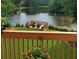 Scenic view from the deck overlooking the lush backyard and serene lake with an outdoor seating area at 2436 Camden Lake Nw Vw, Acworth, GA 30101