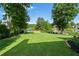 Serene backyard featuring a well-kept lawn, mature trees, and a peaceful lake with an inviting wooden dock at 2436 Camden Lake Nw Vw, Acworth, GA 30101