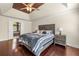Bedroom featuring hardwood floors, a tray ceiling, a ceiling fan, and natural light at 2436 Camden Lake Nw Vw, Acworth, GA 30101