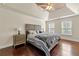 Bedroom featuring hardwood floors, a tray ceiling, a ceiling fan, and natural light at 2436 Camden Lake Nw Vw, Acworth, GA 30101