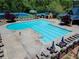 The spacious community pool area offers lounge seating, an outdoor dining space, and a beautiful view of the tennis courts at 2436 Camden Lake Nw Vw, Acworth, GA 30101