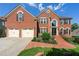 Two-story brick home with a manicured lawn, two-car garage, and brick stairs leading to the front door at 2436 Camden Lake Nw Vw, Acworth, GA 30101