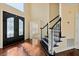 Elegant foyer showcasing hardwood floors, glass front door, and staircase with stone detail at 2436 Camden Lake Nw Vw, Acworth, GA 30101