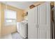 Well-lit laundry room featuring a washer, dryer, storage cabinet and window at 2436 Camden Lake Nw Vw, Acworth, GA 30101