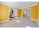 Spacious room featuring carpet, yellow walls, white trim, and views into the foyer and dining room at 2436 Camden Lake Nw Vw, Acworth, GA 30101