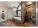 Elegant main bathroom featuring a soaking tub, tiled shower, stone accents, and transom window at 2436 Camden Lake Nw Vw, Acworth, GA 30101