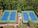 Here's a pair of tennis courts, surrounded by fencing and trees, with lighting for evening matches at 2436 Camden Lake Nw Vw, Acworth, GA 30101