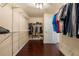 Well-organized walk-in closet with shelving and hanging rods, offering ample storage space with wood floor at 2436 Camden Lake Nw Vw, Acworth, GA 30101