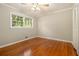 Cozy bedroom featuring hardwood floors, a window with green outdoor views, and neutral wall paint at 3743 Tree Bark Trl, Decatur, GA 30034