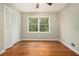 Inviting bedroom with hardwood floors, a large window, and a closet with louvered doors at 3743 Tree Bark Trl, Decatur, GA 30034