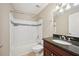 Bathroom with tile tub and shower, granite countertop and wood cabinet at 7104 Santa Fe Pkwy, Atlanta, GA 30350