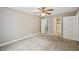A spacious bedroom with three access doors including a closet and bathroom, enhanced by neutral tones and ceiling fan at 7104 Santa Fe Pkwy, Atlanta, GA 30350