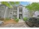 View of exterior of a two-story condo building with gray siding, balconies, landscaping, and parking at 7104 Santa Fe Pkwy, Atlanta, GA 30350