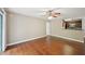 A spacious living area with hardwood flooring, a ceiling fan, and an open view of the adjacent kitchen space at 7104 Santa Fe Pkwy, Atlanta, GA 30350
