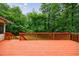 Outdoor deck features orange painted wood, wood railings, and a backyard view at 10565 Shallowford Rd, Roswell, GA 30075