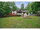 Well-maintained backyard featuring lush landscaping, a spacious lawn, and wooded perimeter at 10565 Shallowford Rd, Roswell, GA 30075