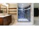 Bathroom featuring a walk-in shower with built-in shelves and dark vanity at 10565 Shallowford Rd, Roswell, GA 30075