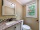 Well-lit bathroom featuring granite countertops, patterned mirror and window at 10565 Shallowford Rd, Roswell, GA 30075