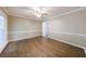 Bright bedroom featuring hardwood floors, neutral paint, and large windows offering a serene view at 10565 Shallowford Rd, Roswell, GA 30075