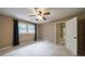 Neutral bedroom features a ceiling fan and a window with natural light at 10565 Shallowford Rd, Roswell, GA 30075