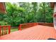 Wooden deck overlooking a private backyard with a lush border of mature trees at 10565 Shallowford Rd, Roswell, GA 30075
