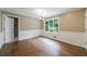 Elegant dining room boasting wood floors, a large window with green views, and classic white wainscoting at 10565 Shallowford Rd, Roswell, GA 30075