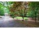 Long driveway leading to a home with a two-car garage, surrounded by trees at 10565 Shallowford Rd, Roswell, GA 30075