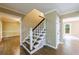 Hallway and staircase featuring hardwood floors and trim at 10565 Shallowford Rd, Roswell, GA 30075