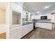 Well-lit kitchen featuring white cabinets, granite countertops, and modern appliances at 10565 Shallowford Rd, Roswell, GA 30075