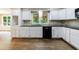 Bright kitchen featuring white cabinets, granite countertops, and wood flooring at 10565 Shallowford Rd, Roswell, GA 30075