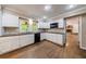 Bright kitchen with white cabinets, black appliances, and beautiful hardwood floors at 10565 Shallowford Rd, Roswell, GA 30075