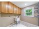 Laundry room featuring ample cabinetry, a utility sink, and a window, combining practicality with natural light at 10565 Shallowford Rd, Roswell, GA 30075