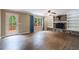 Bright living room featuring a stone fireplace, built-in shelving, hardwood floors, and backyard access at 10565 Shallowford Rd, Roswell, GA 30075