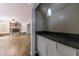 Stylish pantry area featuring granite countertops, white cabinets, and a decorative pendant light fixture at 10565 Shallowford Rd, Roswell, GA 30075