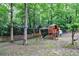 Backyard playground equipment with swing set and playhouse surrounded by beautiful mature trees at 10565 Shallowford Rd, Roswell, GA 30075
