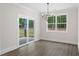Bright dining room with wood floors, modern chandelier, and sliding glass door to the backyard at 150 Doris Path, Dallas, GA 30157