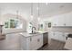 Spacious open concept featuring a kitchen island, stainless appliances, stone fireplace, and backyard view at 150 Doris Path, Dallas, GA 30157