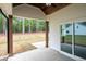 Covered patio features wood ceiling and posts, concrete floor, and sliding glass doors to backyard at 150 Doris Path, Dallas, GA 30157