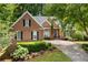 Beautiful brick home boasts a manicured lawn and inviting curb appeal with its blue door and lush landscaping at 4825 Brighton Lake Dr, Cumming, GA 30040