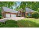 Beautiful brick home with a well-manicured lawn, two-car garage, and mature trees at 4825 Brighton Lake Dr, Cumming, GA 30040
