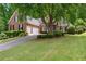 Charming brick home featuring a lush lawn, mature landscaping, and an attached two-car garage at 4825 Brighton Lake Dr, Cumming, GA 30040
